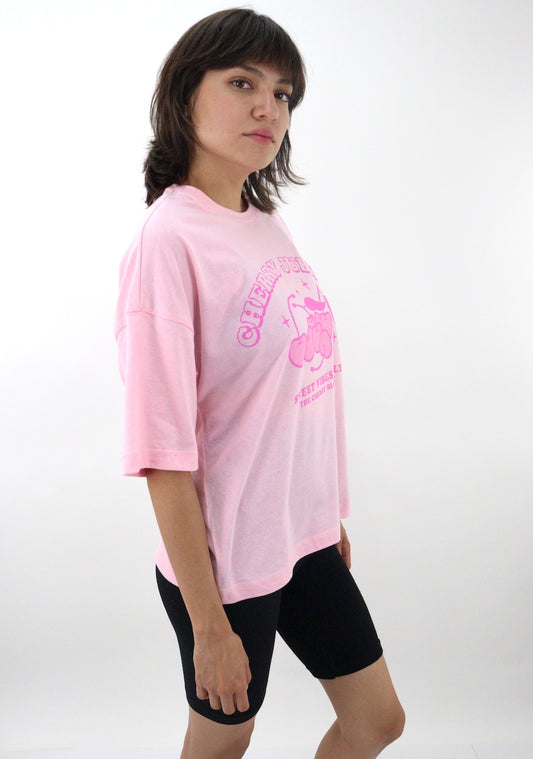 Playera oversize de color rosa con estampado de cerezas