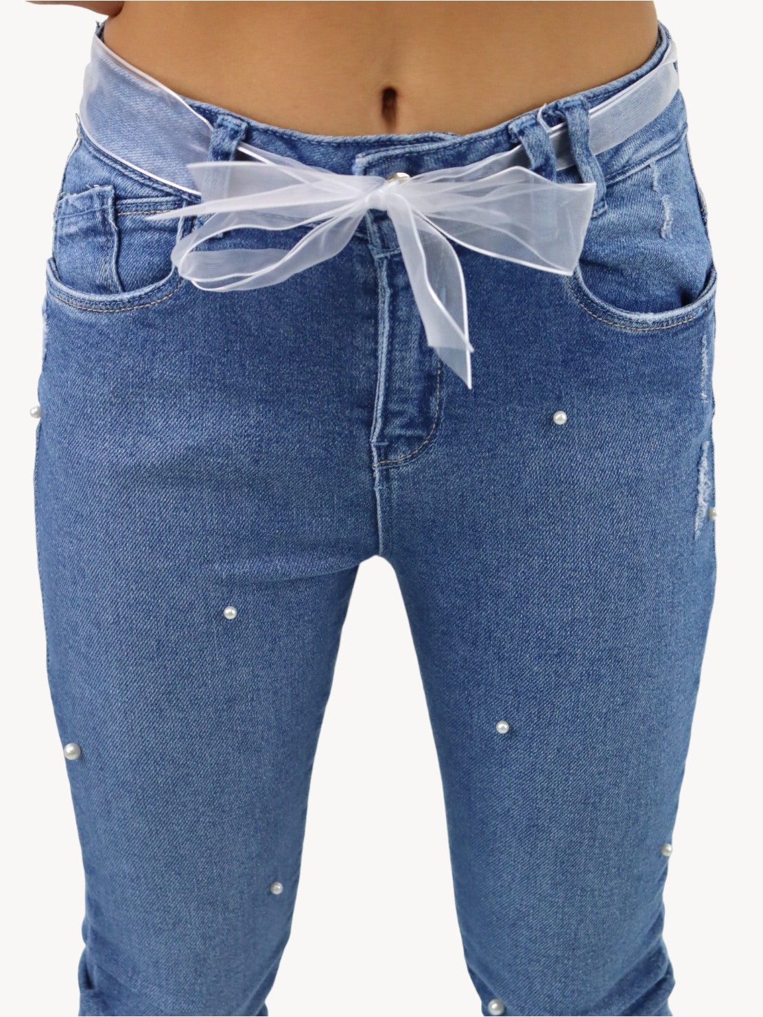 Jeans skinny con cinturón y detalle de perlas