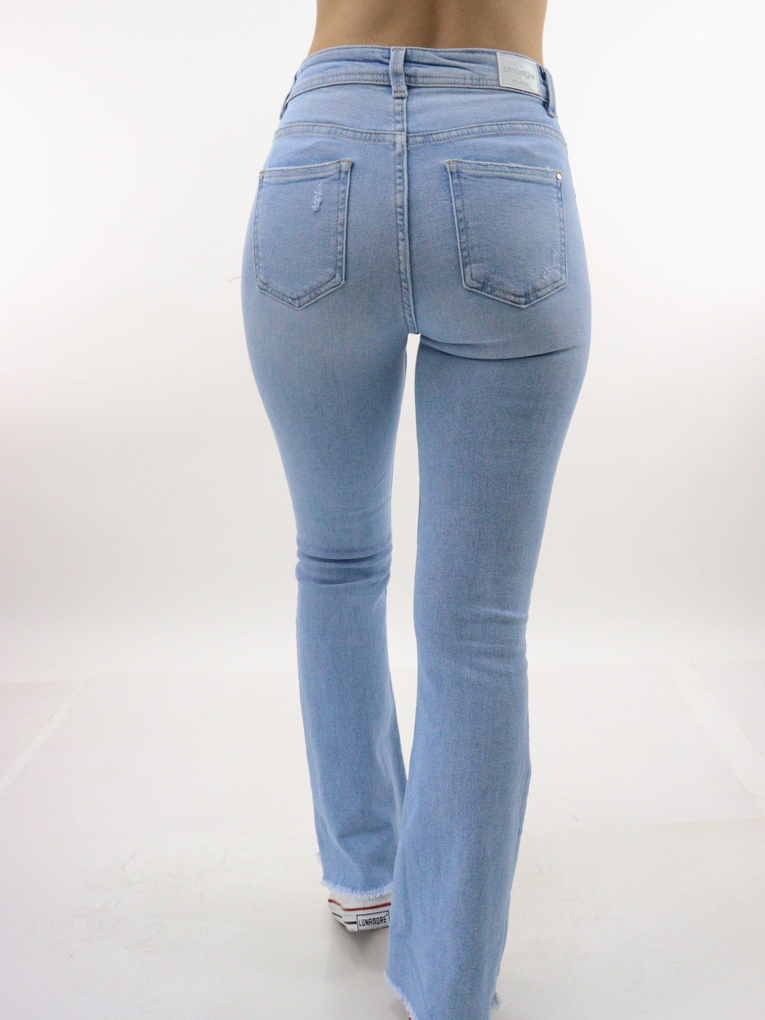 Jeans acampanado tiro alto de color azul claro con destrucción